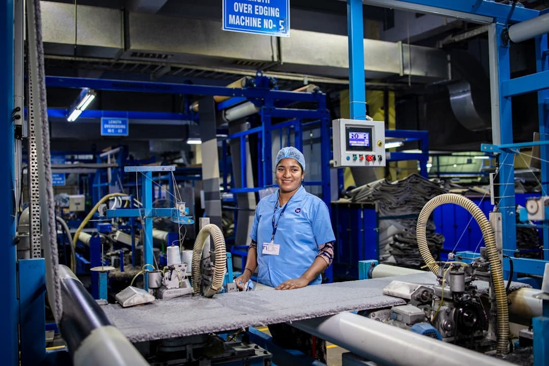 A woman works in a factory with machinery.